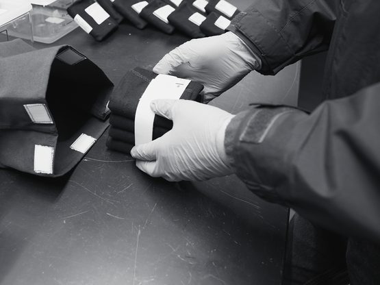 Gloved hands packing labelled sample pouches into an insulated bag
