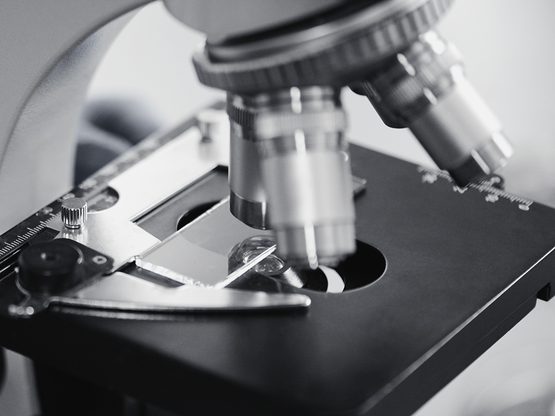 Laboratory microscope with its objective lenses over a slide on the stage